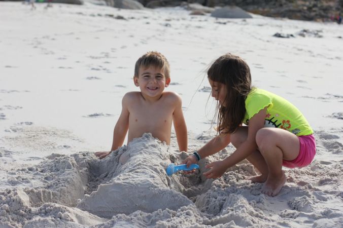 Gabi making a sand mermaid tail for Joah...